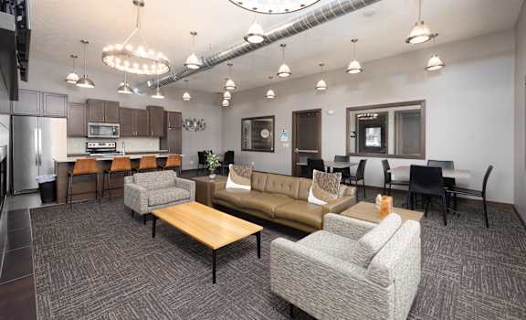 A modern office space with a kitchen area and seating arrangements.