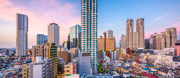 A cityscape with a mix of modern and older buildings under a clear sky.