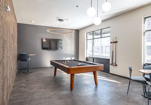 A room with a pool table and a television.