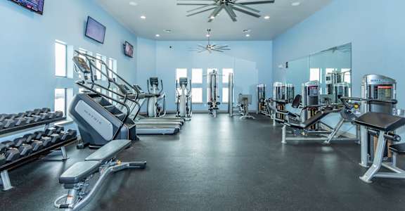 A spacious gym with treadmills, elliptical machines, and other exercise equipment.
