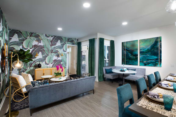 a living and dining area with a blue couch and green chairs