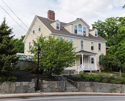a large house with a stone wall in front of it
