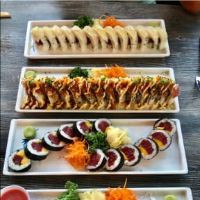 four plates of sushi and other food on a table