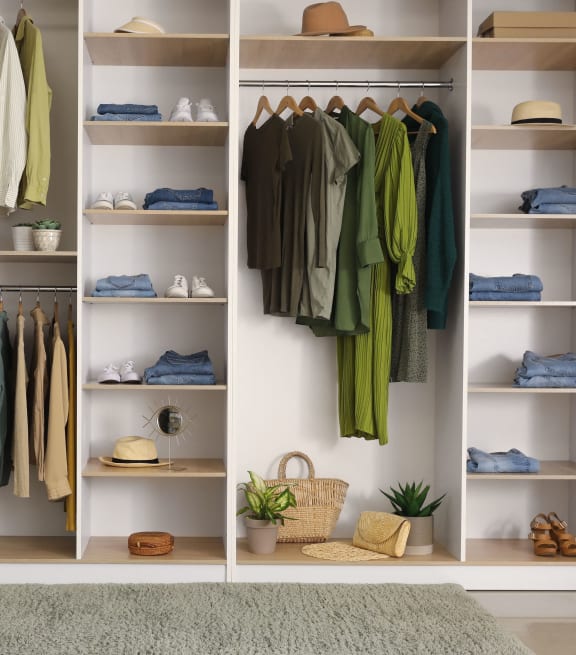 a walk in closet full of clothes and shelves