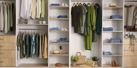 a walk in closet full of clothes and shelves