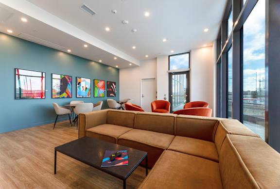A living room with a brown couch, a coffee table, and a large window.