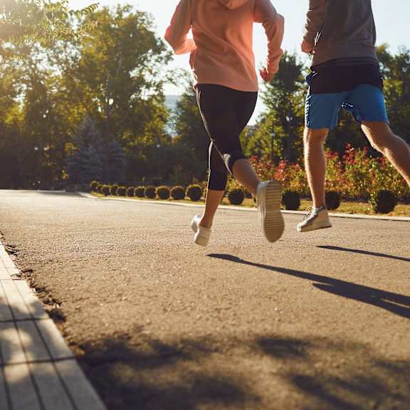 Two people running on a sunny day.