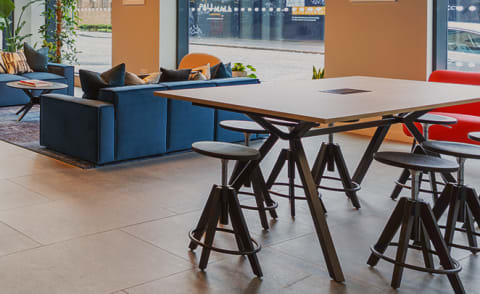 a communal table and chairs in a restaurant with a blue couch