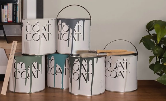 a group of metal canisters sitting on a table next to a plant