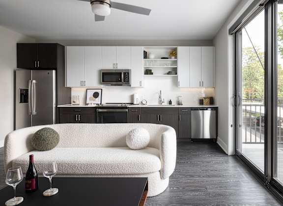 A modern kitchen with a white couch and a ceiling fan.