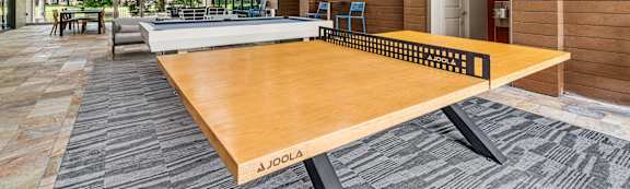 A JOOLA table tennis table in a room with wooden walls.