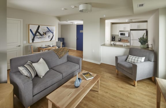 A living room with a couch and two grey chairs