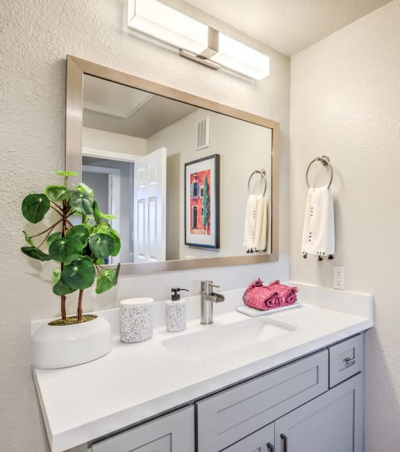 a bathroom with a sink and a mirror and a painting