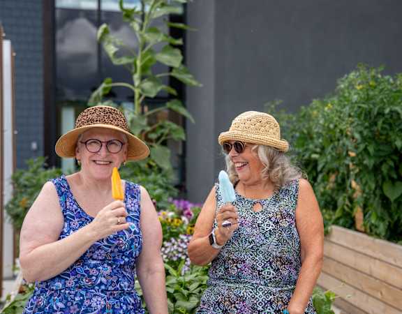 two women eating ice cream in a garden