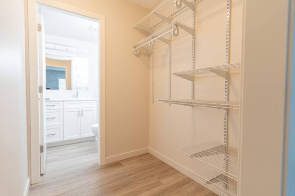 Empty room with shelves and a doorway leading to another room.