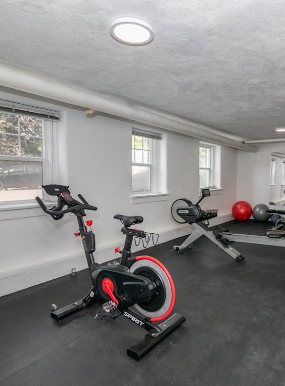 A room with a SpinBike and a red ball.