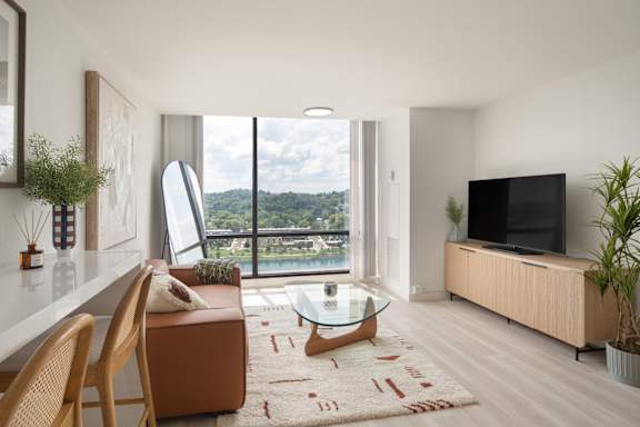 A modern living room with a large window overlooking a landscape.