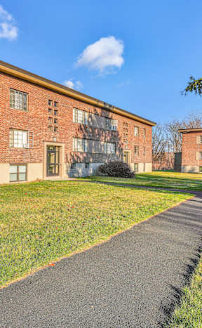 A red brick building with a green lawn in front.