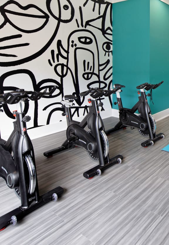 a gym with a row of exercise bikes and balloons