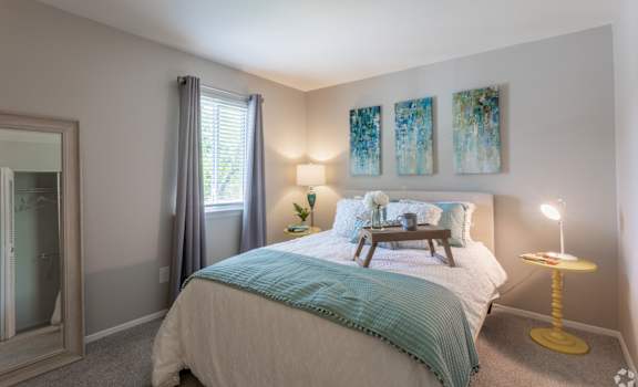 a bedroom with a bed and a nightstand and a window at Courthouse Green Apartments, Chesterfield