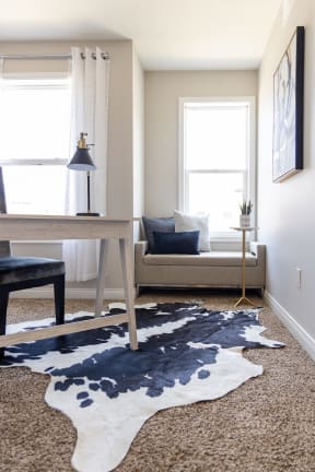a living room with a cowhide rug on the floor and a couch in the background