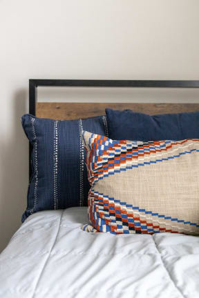 a bed with blue pillows and a white comforter