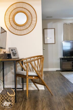 a small desk with a chair in front of it and a television in the background