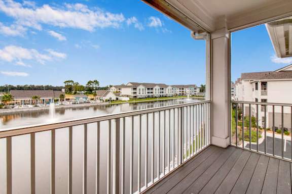 a balcony with a view of a body of water and some houses at Watermark at Urban Blu, Panama City Beach, Florida