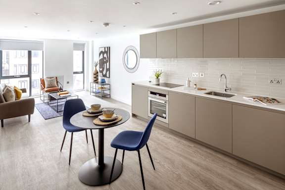 a kitchen and living room with a table and chairs