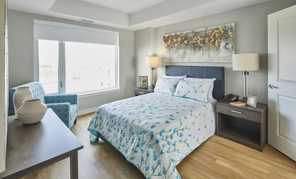 A bedroom with a bed and a chair