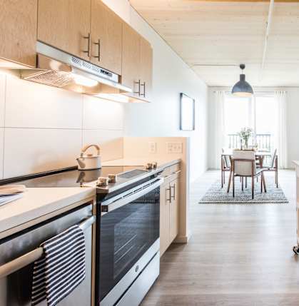 A kitchen with a black oven and a white wall.