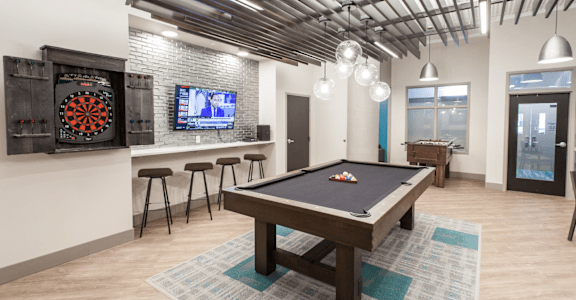 a games room with a pool table and a television  at The Cosmopolitan, St Paul, MN, 55101