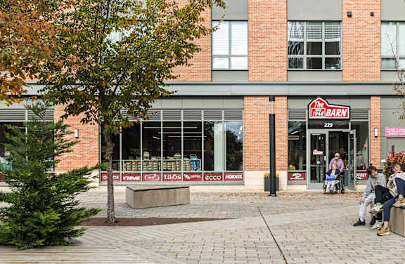 A brick building with a sign that says  at Trio Newton Apartments, Newton