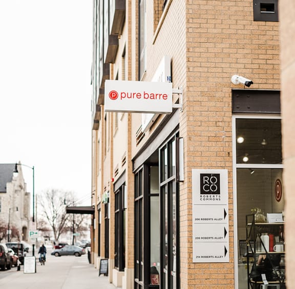 a sign on the side of a building that reads pure barre