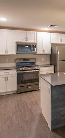 a kitchen with white cabinets and a black stove and refrigerator