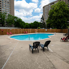a swimming pool at an apartment building with chairs around it