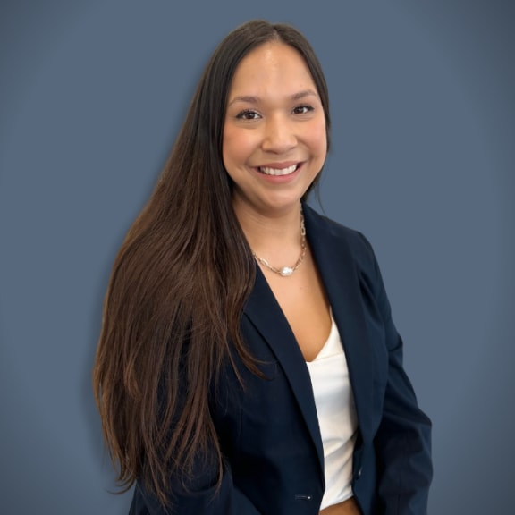 a woman with long brown hair and a blue background smiling