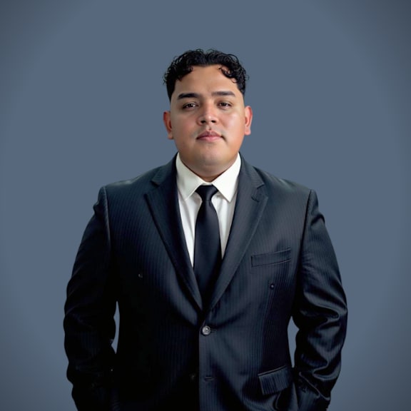 A man in a suit and tie poses for a photo.
