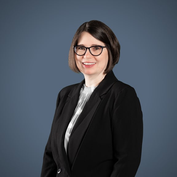 a woman in a black suit and glasses