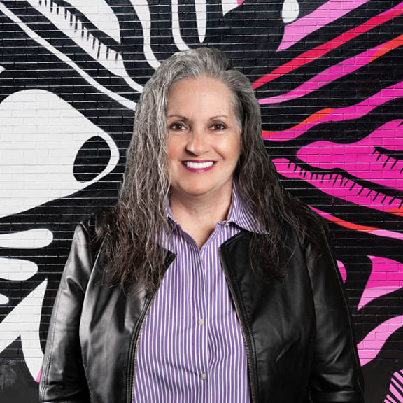 a woman standing in front of a mural