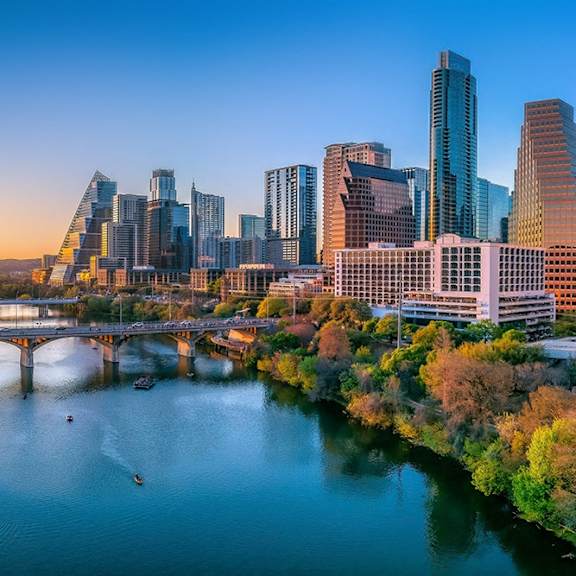 A cityscape with a river and a bridge.