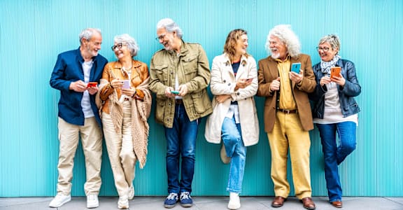 A group of seven people standing in front of a blue wall.