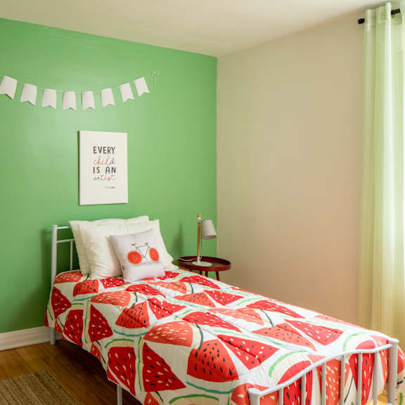 A bedroom with a large bed and a painting on the wall.