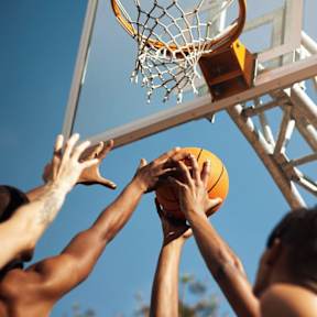 A basketball is in the air as it is about to go through the hoop.