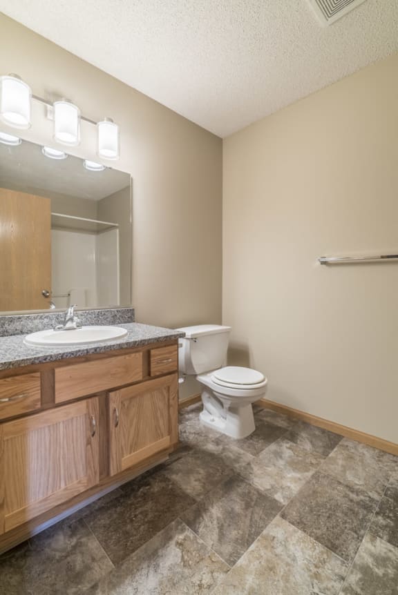 Bathroom with tile floors and warm brown cabinets