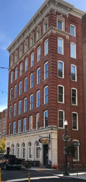 a tall red brick building on a city street