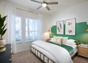 Thumbnail 12 of 19 - a bedroom with a green accent wall and a ceiling fan