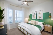 Thumbnail 12 of 19 - a bedroom with a green accent wall and a ceiling fan
