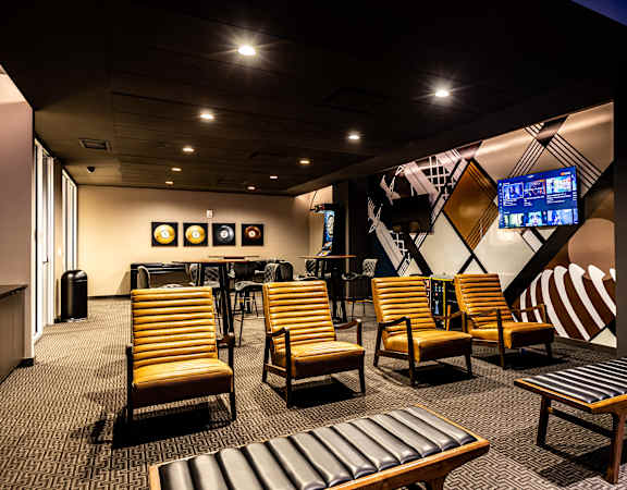 a lounge area with chairs and tables and a television  at The Grand, Missouri
