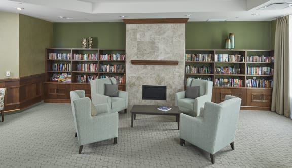 Reading room with fireplace, comfortable chairs and tables. 